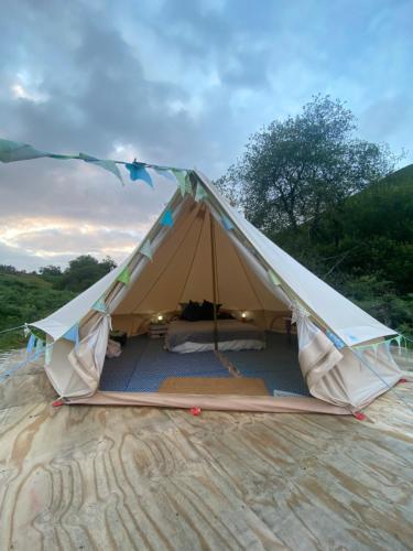 a teepee tent with a canopy in a field at Glyndwr Bell Tent in Builth Wells