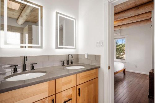 a bathroom with two sinks and two mirrors at Casa Anita in Santa Fe