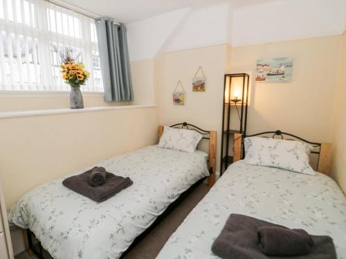 2 camas individuales en una habitación con ventana en Beausite, en Colwyn Bay