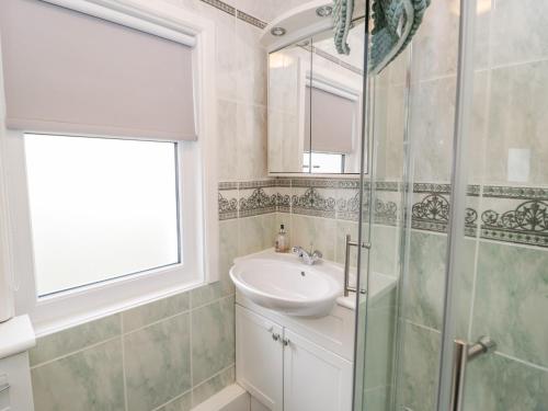 科爾溫灣的住宿－Beausite，一间带水槽和玻璃淋浴的浴室