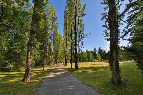 a path in a park with trees and grass at Casa De Kai in Mill Bay