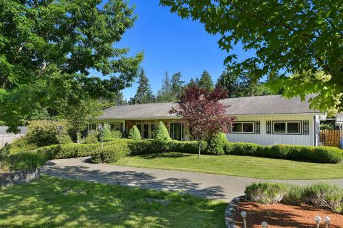 a house with a landscaped yard in front of it at Casa De Kai in Mill Bay
