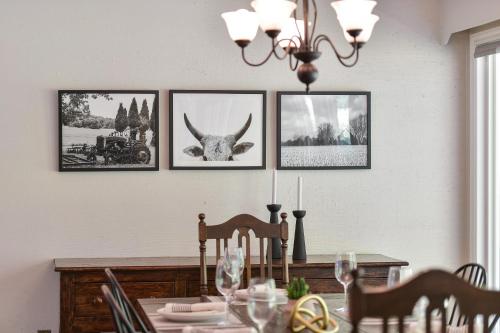 a dining room table with four pictures on the wall at Casa De Kai in Mill Bay