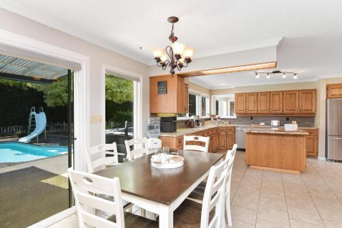 a kitchen and dining room with a table and chairs at Casa De Kai in Mill Bay