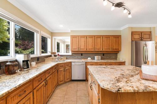 a kitchen with wooden cabinets and granite counter tops at Casa De Kai in Mill Bay