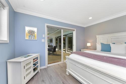 a bedroom with blue walls and a bed and a window at Casa De Kai in Mill Bay