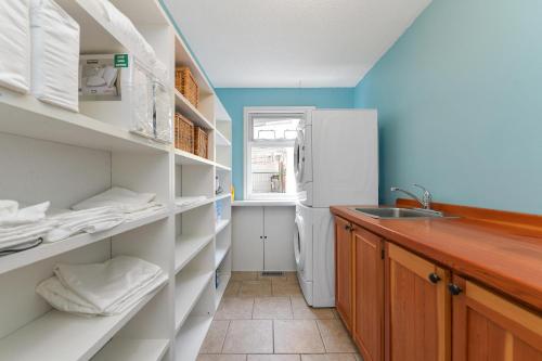 a kitchen with white shelves and a white refrigerator at Casa De Kai in Mill Bay