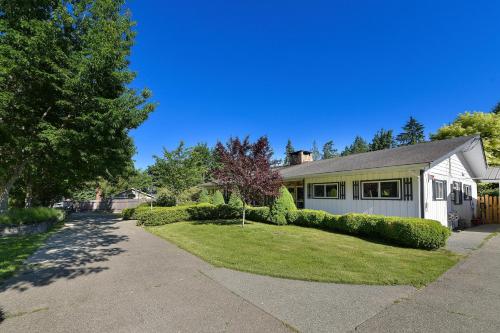 a house with a yard with a driveway at Casa De Kai in Mill Bay