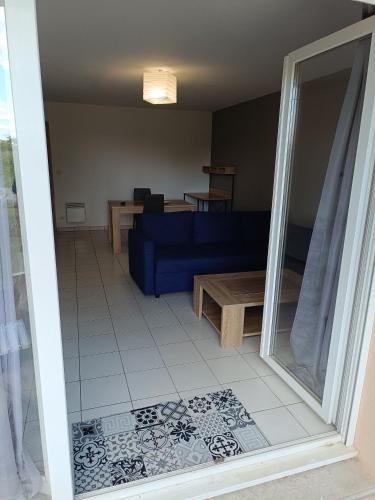 een woonkamer met een blauwe bank en een tafel bij Appartement T2 in Limoges
