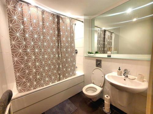 a bathroom with a toilet and a sink and a shower at Long-term Retreat! Family & Business - 5 Beds City Apt & Parking - 中国搬迁 in Leeds