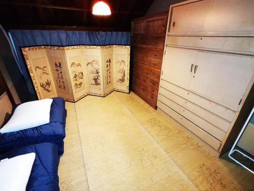 a small room with a bed and cabinets in it at Fukubatake in Yoshino