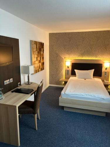 Schlafzimmer mit einem Bett, einem Schreibtisch und einem Schreibtisch in der Unterkunft Hotel Kaiserhof in Siegburg