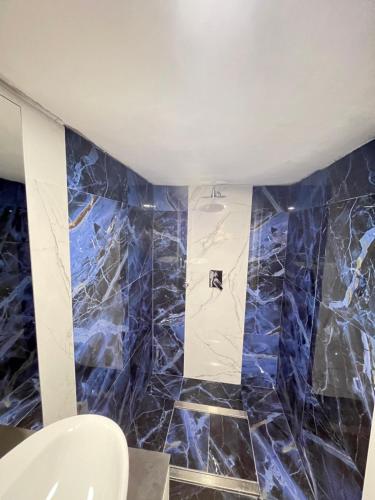a bathroom with blue marble walls and a toilet at Il Bunker in Bolano