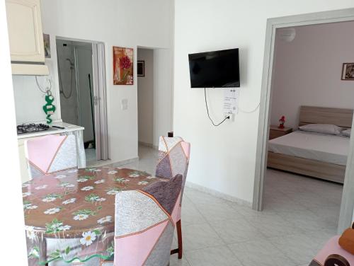 a living room with a table and a bedroom at Sardinia ovest in Oristano