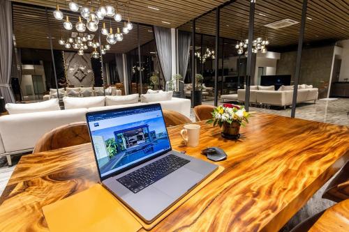 a laptop computer sitting on a wooden table at Villa Obsidian, sea view and walk to Choeng Mon beach in Choeng Mon Beach