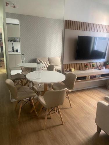 a living room with a table and chairs and a tv at Duo Interlagos Aluguel apenas do quarto in São Paulo