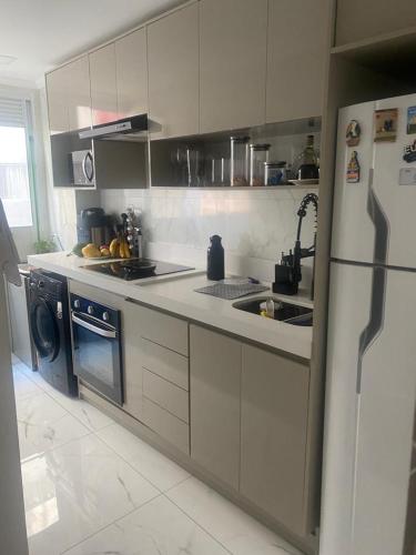 a kitchen with a sink and a refrigerator at Duo Interlagos Aluguel apenas do quarto in São Paulo