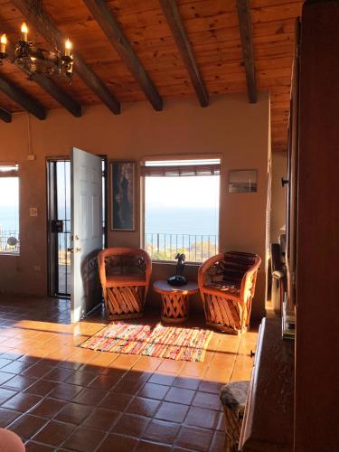 a living room with chairs and a view of the ocean at Su Casa in Ensenada
