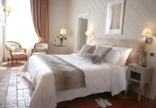 a bedroom with a large bed with white sheets and pillows at Chambres d'hôtes Relais Mira Peis in Mirepoix