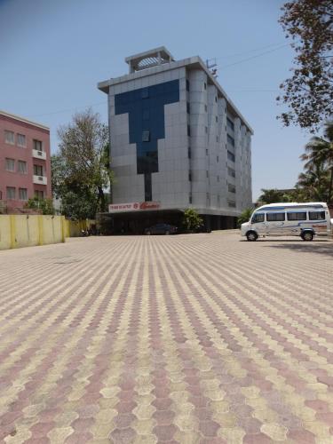 a bus is parked in front of a building at Hotel Abigail Regency in Shirdi