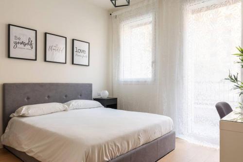 - une chambre avec un grand lit et trois photos sur le mur dans l'établissement Kaizen House - Bilocale De Angeli, à Milan