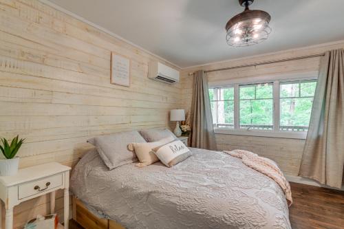 Schlafzimmer mit Holzwänden und einem Bett mit Kissen in der Unterkunft Cozy Tennessee Retreat with Patio and Charcoal Grill! in Linden