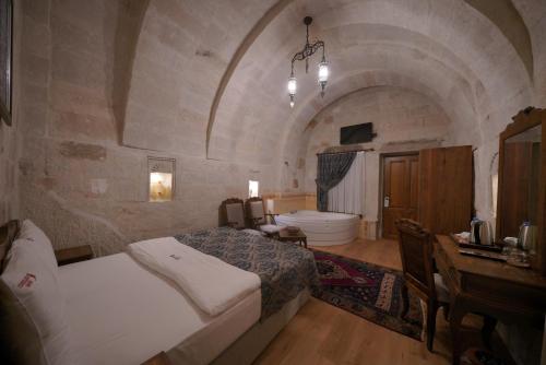 a bedroom with a bed and a tub in a room at Fairyland Cave Hotel in Goreme