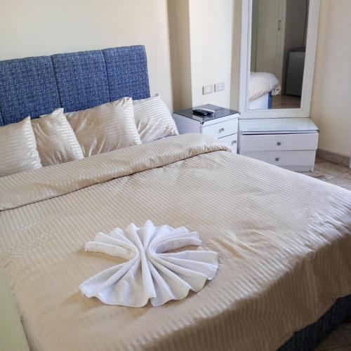 a large white bed with a white flower on it at New Panorama Palace in Cairo