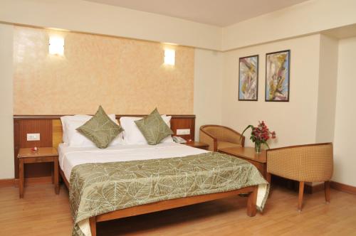a hotel room with a bed and a table at Hotel Abigail Regency in Shirdi