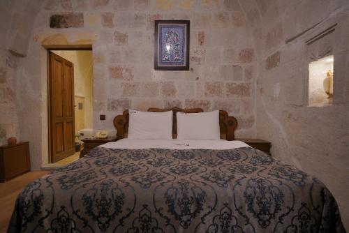 a bedroom with a bed in a stone wall at Fairyland Cave Hotel in Goreme
