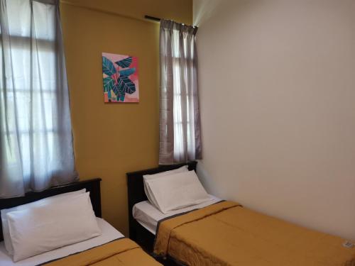 a small room with two beds and a window at G FORTUNE HOTEL + in George Town