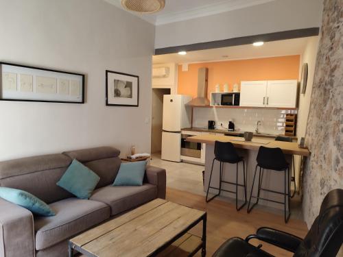 ein Wohnzimmer mit einem Sofa und einer Küche in der Unterkunft Location appartement T3 à Sète in Sète
