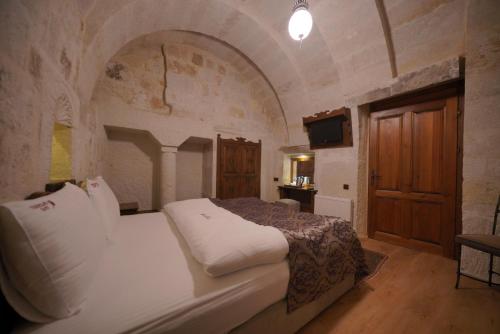 a bedroom with a large bed in a stone room at Fairyland Cave Hotel in Goreme