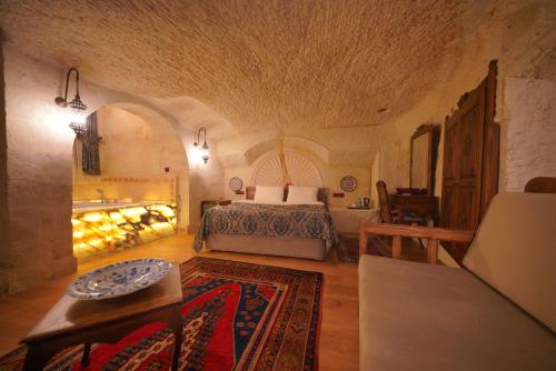 a bedroom with a bed and a table in a room at Fairyland Cave Hotel in Goreme