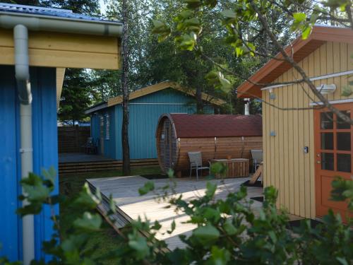 un patio trasero con una terraza de madera y un cobertizo en Backyard Village, en Hveragerði