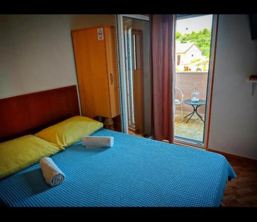 una camera da letto con un letto con una coperta blu e una finestra di Studio Manora Sucuraj a Sućuraj (San Giorgio)