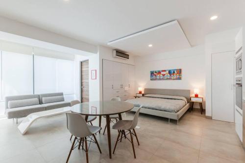 a bedroom with a bed and a table and chairs at Moderno y amplio estudio en el centro de Playa in Playa del Carmen