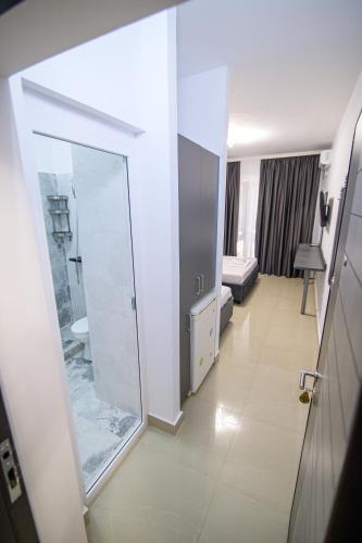 a bathroom with a mirror and a room with a bed at Cazare Dumbrava in Eforie Sud