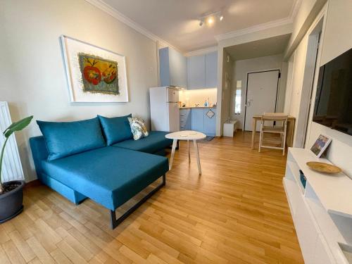 een woonkamer met een blauwe bank en een tafel bij Iris in Athene