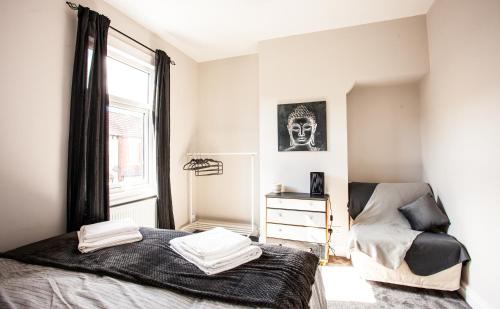 a bedroom with a bed and a chair and a window at Contractor house, sleeps 7, close to restaurant's & bars, long stays available, Oveyo Accommodation in Middlesbrough