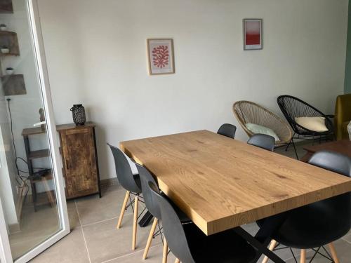 a wooden table and chairs in a room at Appartement T4 terrasse et vue in Istres