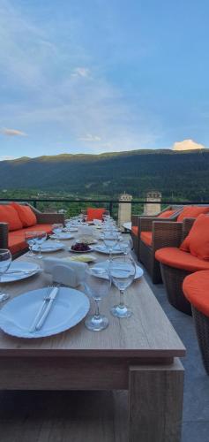 a wooden table with plates and wine glasses on it at Mestia 4 season in Mestia