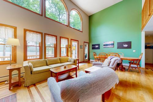 Gilmanton的住宿－Loon Retreat，大型客厅设有绿色的墙壁和窗户。