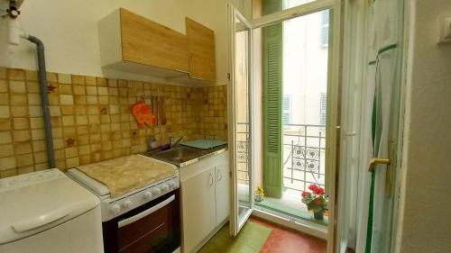 une petite cuisine avec un évier et une fenêtre dans l'établissement Charmant studio, à Cannes