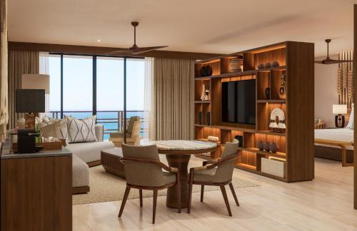 a living room with a table and a room with a bed at Secrets Playa Blanca Costa Mujeres - All Inclusive Adults Only in Cancún