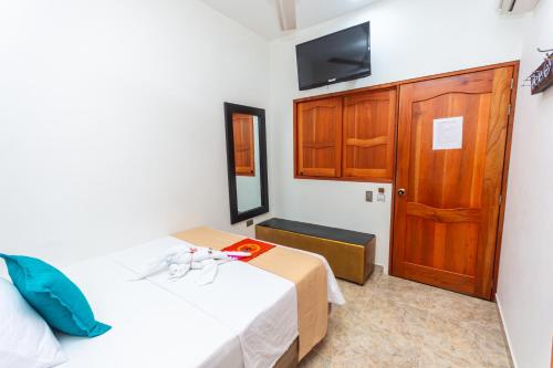 a bedroom with a bed and a wooden door at Hotel Buddha Mystic By Del Toro in Doradal