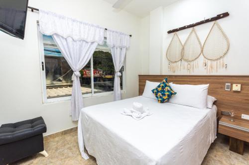 a bedroom with a white bed and a window at Hotel Buddha Mystic By Del Toro in Doradal