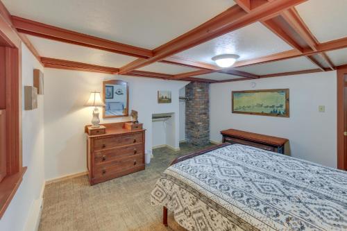 a bedroom with a bed and a dresser and a mirror at Calumet Township Cottage about 1 Mi to Lake Superior in Calumet