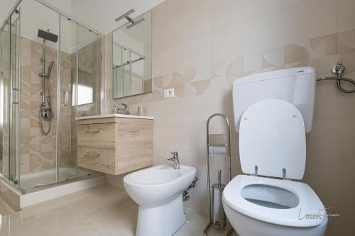a bathroom with a toilet and a shower and a sink at Casa Vacanza Egan Scanzano J in Scanzano