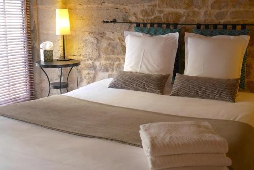a bedroom with a large white bed with pillows and a table at Nos chambres en ville B&B in Lyon